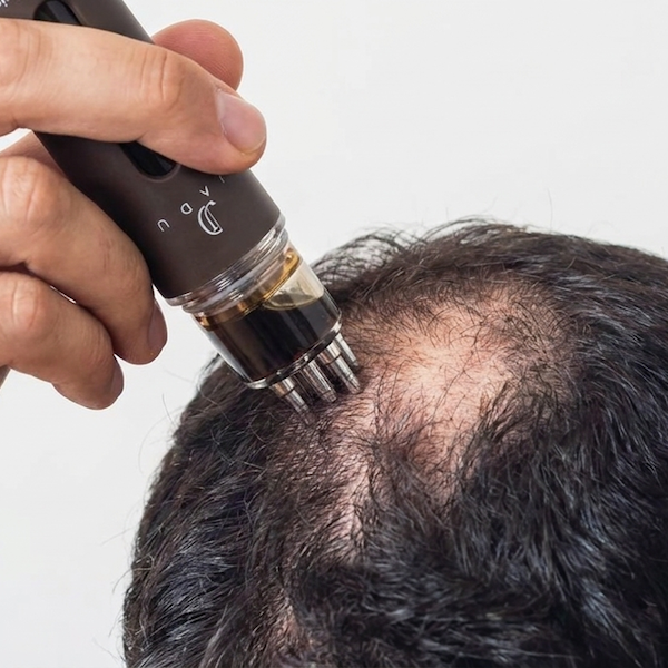 Jadu Beauty Magic drip applicator being applied to hair for thicker and fuller looking hair