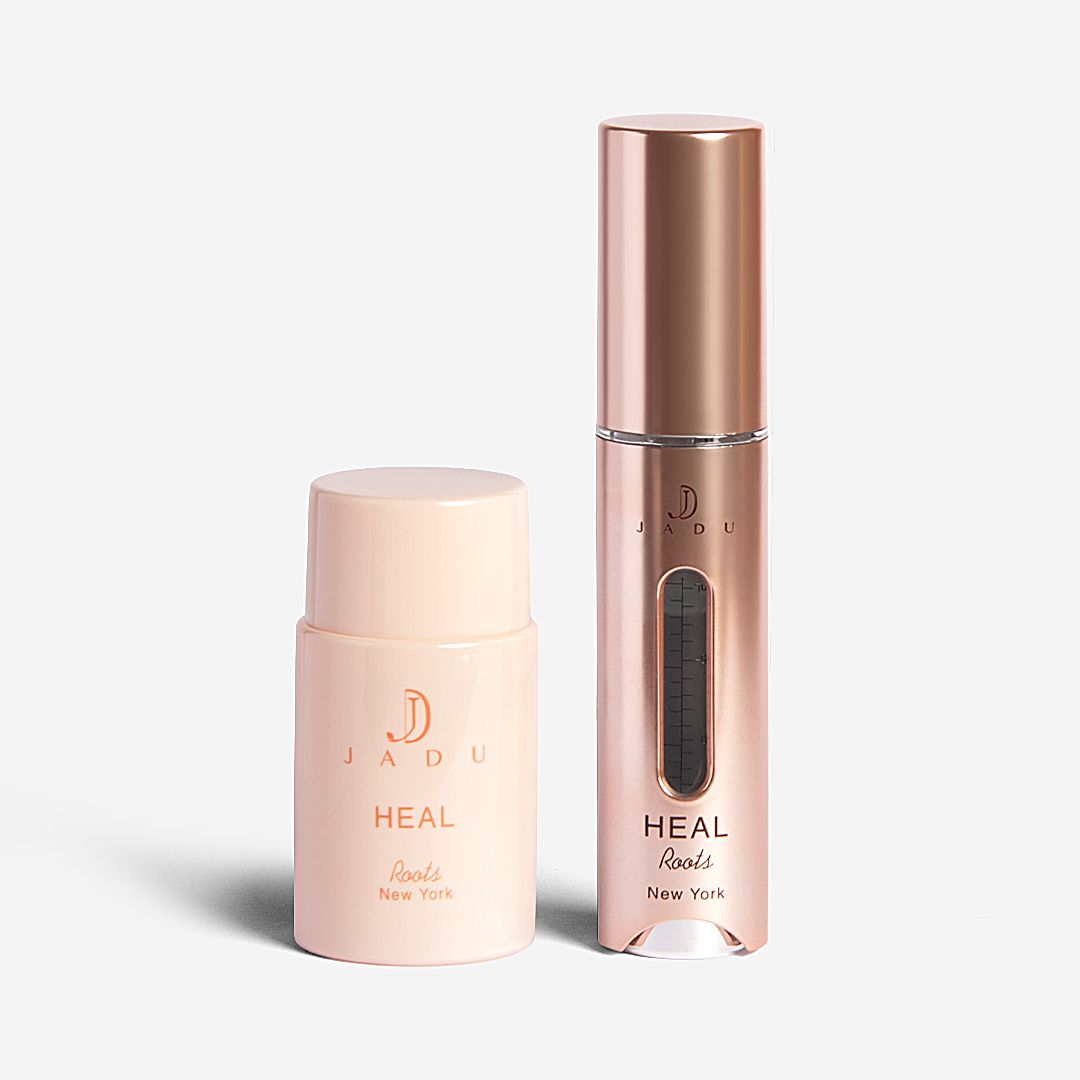 The Jadu Heal Roots bottle shown with its rose-gold scalp applicator wand.