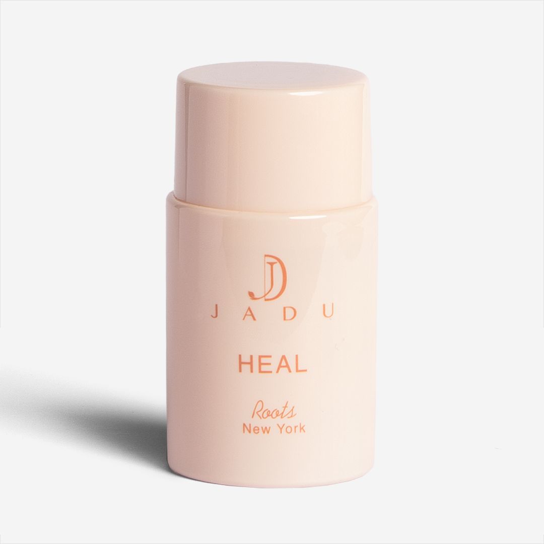 A peach bottle of Jadu Heal Roots scalp treatment.