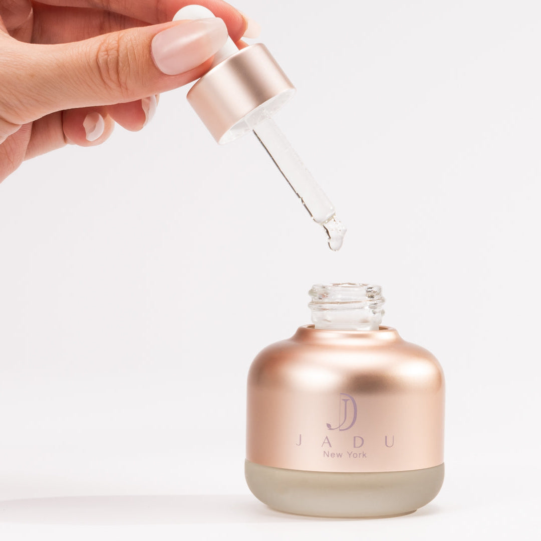 Hand holding dropper applying lightweight split ends hair oil from bottle