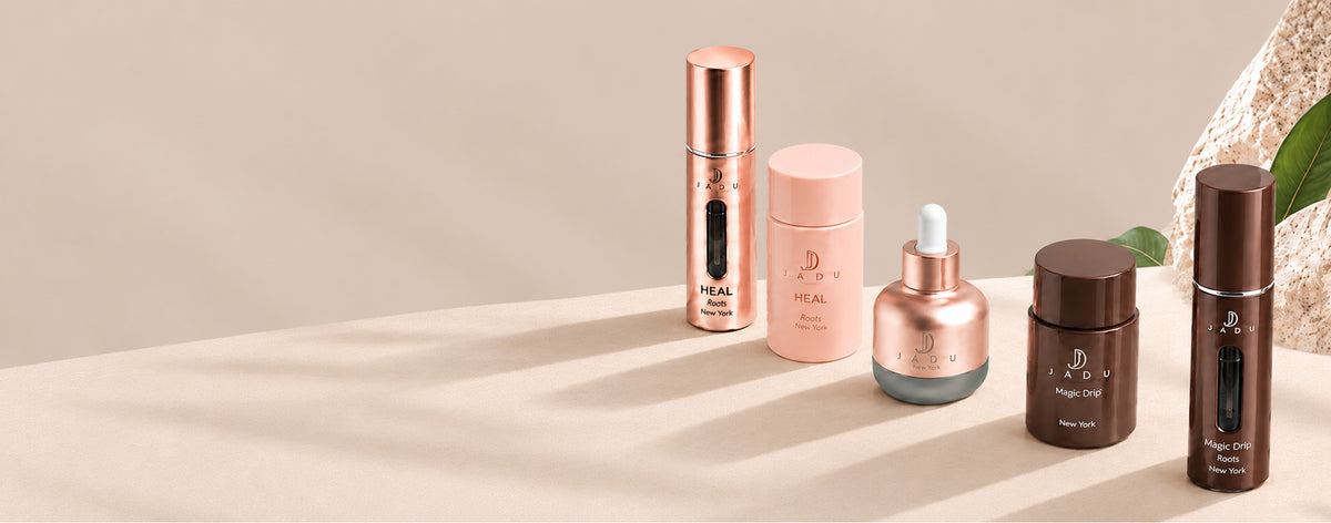 The Jadu hair care lineup on a sunlit beige ledge: Heal Roots, Split Ends Care and Magic Drip.