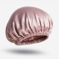 A dusty rose silk sleep bonnet with an elastic band.