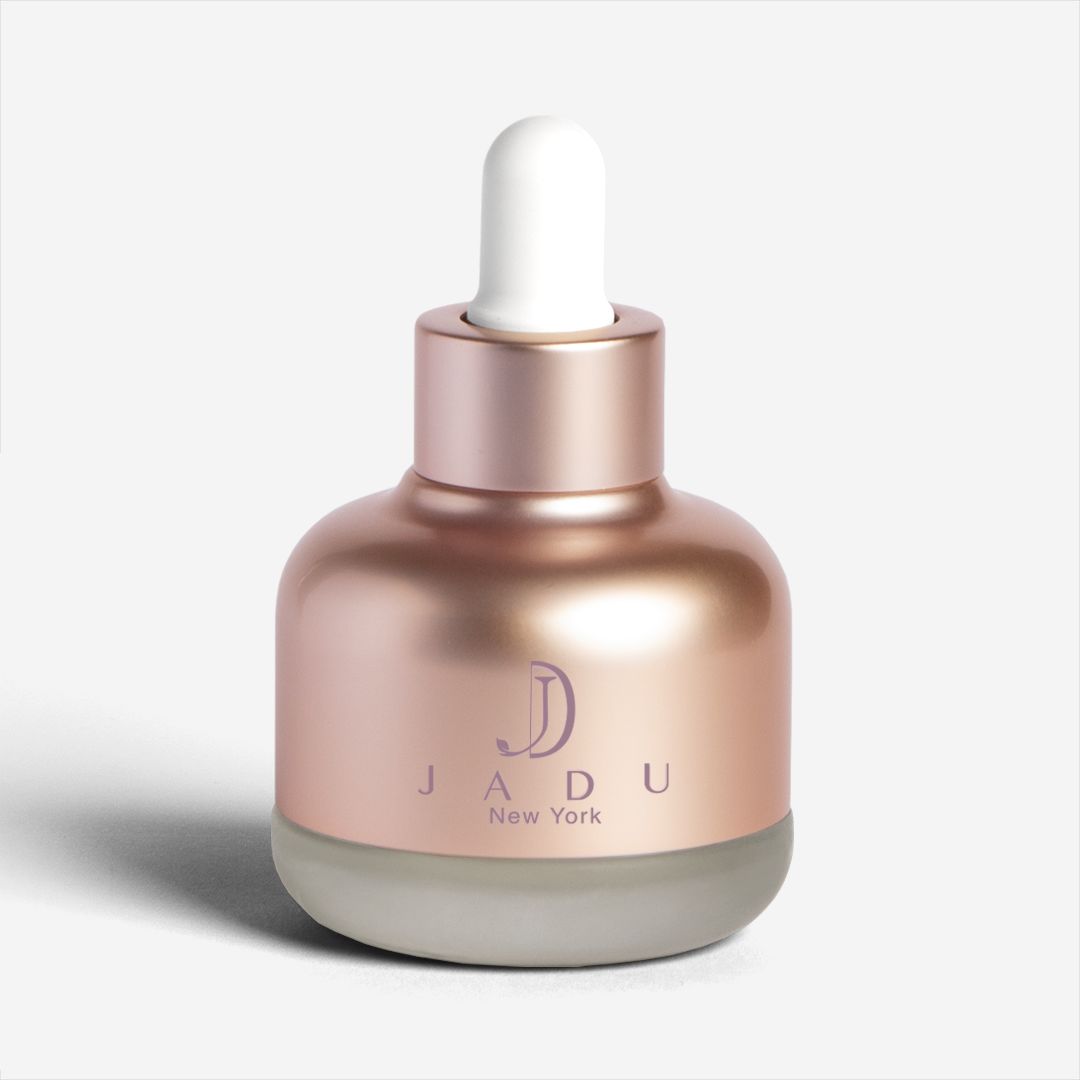 A rose-gold dropper bottle of Jadu Split Ends Care damaged hair oil.